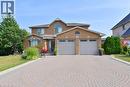 Brick exterior with a prominent arched window and a two-car garage - 36 Tommar Place, Hamilton, ON  - Outdoor 