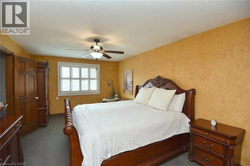 Bedroom with textured golden-toned walls and grey carpeting - 36 Tommar Place, Hamilton, ON - Indoor Photo Showing Bedroom
