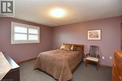 Bedroom featuring wall-to-wall carpeting, a built-in window with white plantation shutters, and a flush-mount ceiling light fixture - 