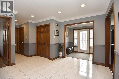 Foyer featuring ceramic tile flooring, recessed lighting, crown molding, two-tone wall treatment, and a paneled entry door with sidelights - 36 Tommar Place, Hamilton, ON - Indoor Photo Showing Other Room