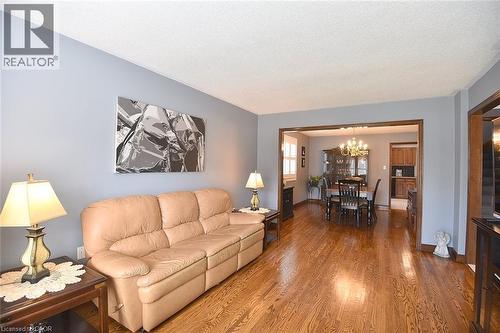 Open-concept living space featuring wood-finish flooring, light blue wall paint, and a white ceiling - 36 Tommar Place, Hamilton, ON - Indoor Photo Showing Living Room