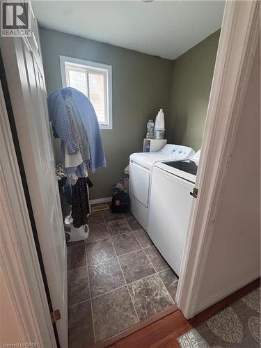 Dedicated laundry area featuring a window, tile-look flooring, and a pair of white appliances - 452 Beaumont Crescent, Kitchener, ON - Indoor Photo Showing Laundry Room