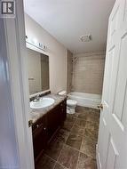 Full bathroom with a dark wood-finish vanity, integrated sink, and laminate countertop - 