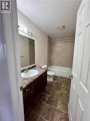 Full bathroom with a dark wood-finish vanity, integrated sink, and laminate countertop - 452 Beaumont Crescent, Kitchener, ON - Indoor Photo Showing Bathroom