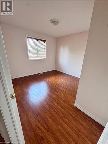 Neutral wall tones complement the wood-finish flooring in this interior space - 452 Beaumont Crescent, Kitchener, ON - Indoor Photo Showing Other Room