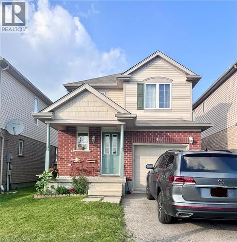 Two-story residence featuring a brick and siding facade, covered front porch, an attached single-car garage, and a concrete driveway - 452 Beaumont Crescent, Kitchener, ON - Outdoor