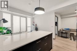 Kitchen island featuring a light-toned quartz countertop and dark cabinetry with silver-toned hardware - 