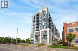 Contemporary multi-story building featuring a facade of light-colored panels and dark-framed windows - 