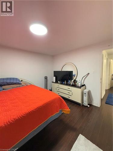 Dark wood-finish flooring with white baseboards and a ceiling-mounted light fixture - 181 Thaler Avenue, Kitchener, ON 
