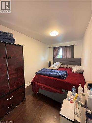 Room featuring wood-finish flooring, white walls, and a window with dark drapery - 181 Thaler Avenue, Kitchener, ON 