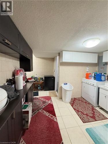 Utility room featuring ceramic tile flooring, built-in cabinetry, and a full-size washer and dryer - 181 Thaler Avenue, Kitchener, ON 
