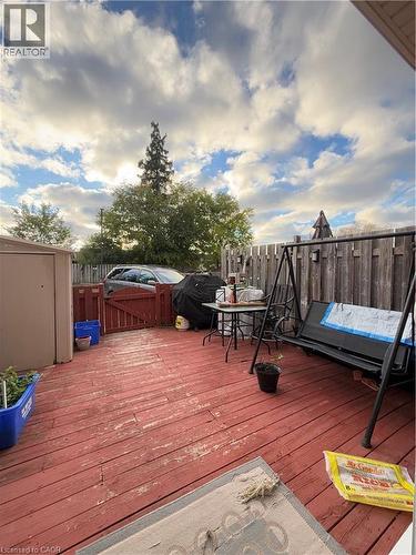 Expansive red-stained wood deck featuring a privacy fence and a storage shed - 181 Thaler Avenue, Kitchener, ON 