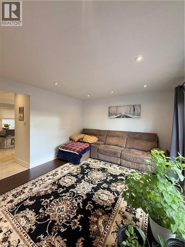 Spacious living area featuring dark wood-finish flooring, recessed lighting, and white walls - 181 Thaler Avenue, Kitchener, ON 