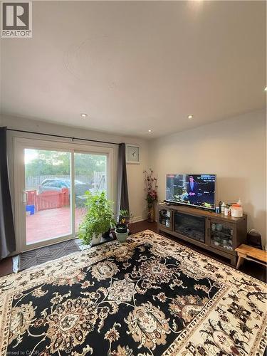 Living area featuring wood-finish flooring, recessed ceiling lighting, and a sliding glass door providing access to an outdoor deck - 181 Thaler Avenue, Kitchener, ON 