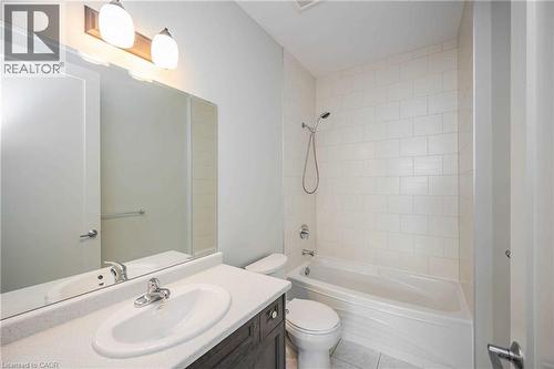 Bathroom featuring a single vanity with a white countertop, an oval undermount sink, and a chrome faucet - 112 King Street E Unit# 907, Hamilton, ON 