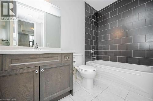 Bathroom featuring a vanity with a light wood-finish cabinet, integrated sink, and chrome faucet - 112 King Street E Unit# 907, Hamilton, ON 