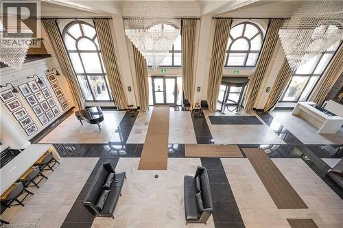Expansive foyer featuring a mosaic tile floor, multiple chandeliers, and tall arched windows with drapes - 112 King Street E Unit# 907, Hamilton, ON 