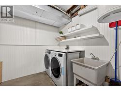 Dedicated laundry space with added storage and utility sink. - 