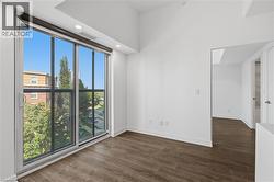 Expansive sliding glass doors, wood-finish flooring, recessed lighting, white walls, and a visible doorway - 