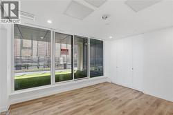 Expansive wall of sliding glass doors opening to an outdoor patio with green surfacing - 