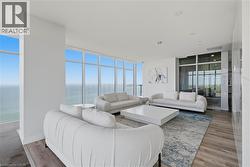 Expansive room featuring floor-to-ceiling windows, high ceilings, recessed lighting, and wood-finish flooring - 