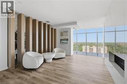 Expansive interior with full-height windows, wood-finish flooring, a contemporary built-in fireplace, and a decorative slatted room divider - 