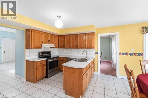 Kitchen featuring wood cabinetry, white tile flooring, white countertops, a stainless steel range, and a dual basin sink - 381 Kerman Avenue, Grimsby, ON - Indoor Photo Showing Kitchen With Double Sink