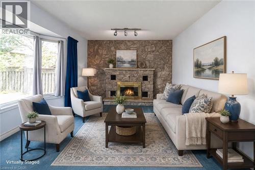 Living area featuring a stone accent wall with a fireplace, recessed firebox, and stone mantel - 381 Kerman Avenue, Grimsby, ON - Indoor Photo Showing Living Room With Fireplace