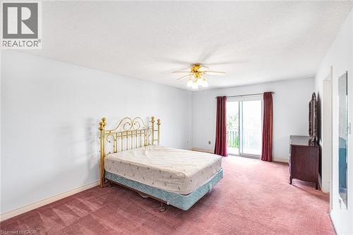 Room with white walls, red carpeting, a ceiling fan with integrated lighting, and a glass sliding door - 381 Kerman Avenue, Grimsby, ON - Indoor Photo Showing Bedroom