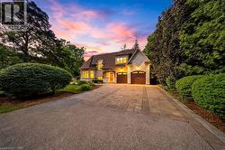 Elegant stone and stucco exterior with dormer windows and a natural wood front door - 
