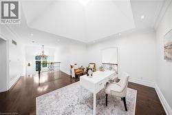 Hardwood flooring throughout a spacious loft area featuring a vaulted ceiling with skylight and recessed lighting - 