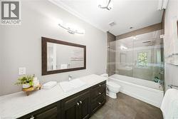 Bathroom featuring a dark wood-finish vanity with a white countertop and vessel sink - 