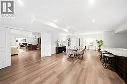 Spacious interior featuring wood-finish flooring, recessed lighting, and a built-in bar with a light-toned countertop - 