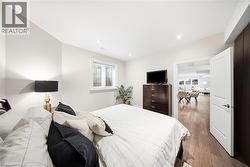 Recessed lighting illuminates this room featuring light neutral walls and wood-finish flooring - 