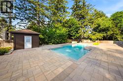Rectangular in-ground swimming pool surrounded by extensive paver patio - 