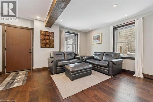 Inviting living area featuring rich wood-finish flooring, recessed lighting, and a prominent exposed beam accent - 838 Moore Street, Cambridge, ON - Indoor Photo Showing Living Room