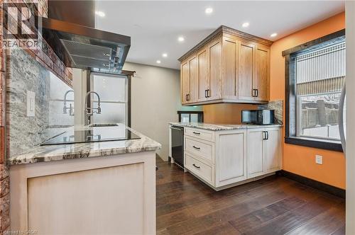 Modern kitchen featuring dark wood-finish flooring, light-toned lower cabinetry, and complementary stone countertops - 838 Moore Street, Cambridge, ON - Indoor Photo Showing Kitchen