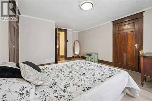 Bedroom featuring light-toned walls, wood-finish flooring, and white crown molding - 838 Moore Street, Cambridge, ON - Indoor Photo Showing Bedroom