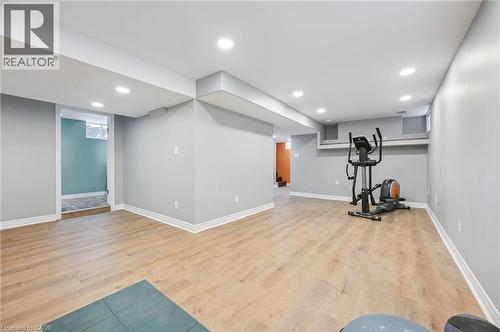 Spacious lower-level room featuring wood-finish flooring, recessed lighting, and light grey painted walls - 838 Moore Street, Cambridge, ON - Indoor