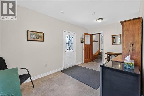 Entryway featuring tile flooring, a white exterior door with decorative glass inserts, and a wooden interior door - 1629 Gregory Road, St. Catharines, ON 