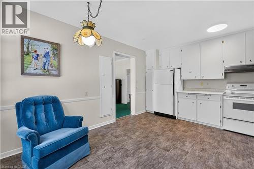 Kitchen featuring white cabinetry, white appliances including a refrigerator and range, a white countertop, and vinyl flooring - 1629 Gregory Road, St. Catharines, ON 