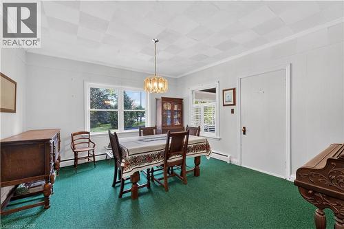Dining area featuring a central chandelier, multiple windows, a paneled ceiling, and crown molding - 1629 Gregory Road, St. Catharines, ON 