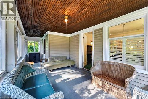 Covered porch featuring a wood-paneled ceiling, painted wood flooring, horizontal siding, and multiple windows - 1629 Gregory Road, St. Catharines, ON 