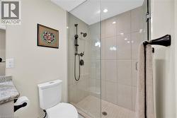 Contemporary bathroom featuring a frameless glass shower enclosure with matte black fixtures, full-height tile surround, and a coordinating tiled shower pan - 