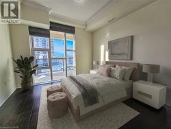 Floor-to-ceiling windows with Roman shades, rich dark wood-finish flooring, and crown molding define this space - 