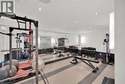 Dedicated fitness area featuring extensive mirrored walls and recessed lighting - 