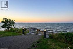 Waterfront property featuring a gravel path and two illuminated bollard lights - 