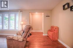 Living area featuring wood-finish flooring, a multi-panel window, and neutral wall tones - 