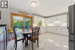 Bright kitchen featuring white cabinetry, light countertops, and tile flooring - 