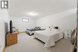 Carpeted room featuring white walls, a single window with wood trim, and a ceiling-mounted light fixture - 